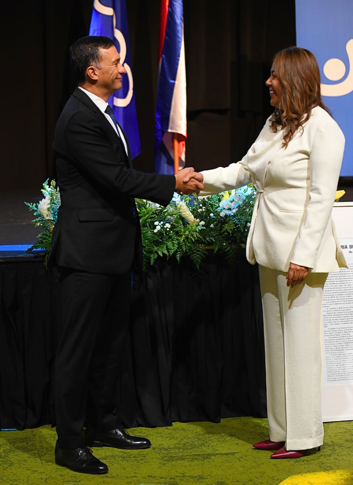 Adrián Álvarez, gerente general de Coopenae, y Alexandra Marquéz Massino, gerente general de CoopeAnde, estrechan sus manos en el marco del proceso de integración de ambas cooperativas, cuyo avance fue aprobado por sus asambleas de delegados. Foto: Agencia Novum para Coopenae.